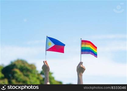 hands showing LGBTQ Rainbow and Philippines flag on nature background. Support Lesbian, Gay, Bisexual, Transgender and Queer community and Pride month concept