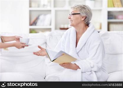 Hands stretched out an elderly woman a cup of