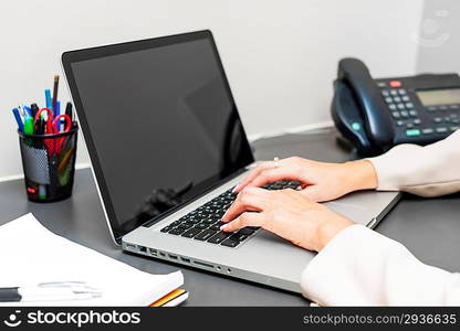 Hands typing on laptop keyboard