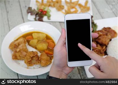Hands using smart phone with blank screen over blur food background, mock up, template, food online and delivery concept