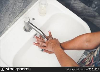 Hands washing for prevention of novel Coronavirus Disease 2019 or COVID-19 . People wash hands at bathroom sink to clean the virus infection.
