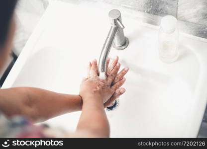 Hands washing for prevention of novel Coronavirus Disease 2019 or COVID-19 . People wash hands at bathroom sink to clean the virus infection.