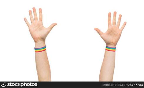 hands with gay pride rainbow wristbands. lgbt, same-sex relationships and homosexual concept - close up of male hands wearing gay pride awareness wristbands