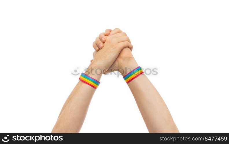 hands with gay pride wristbands in winning gesture. lgbt, same-sex relationships and homosexual concept - close up of male hands wearing gay pride awareness wristbands making winning gesture