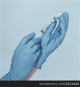 hands with gloves holding vaccine syringe