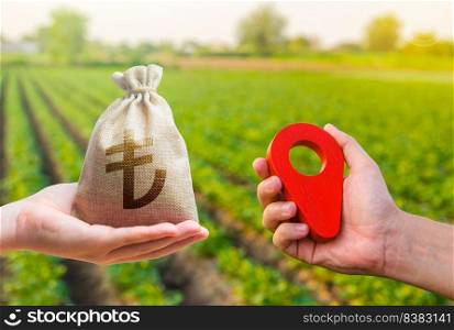 Hands with location pin and turkish lira money bag. Land market. Estimation cost of plots. Transport and construction industry. Buying and selling land. Agriculture agribusiness.