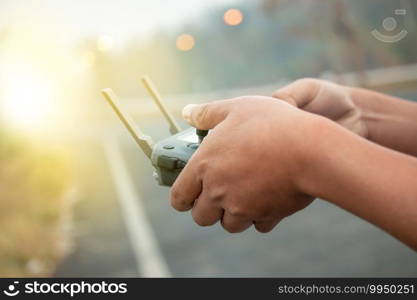 hands with remote controller of drone outside.