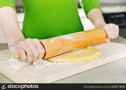 Hands with rolling pin and cookie dough