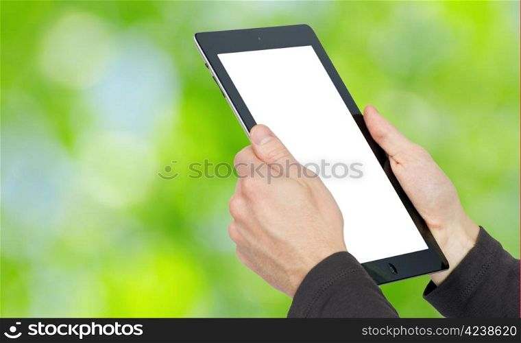 hands with tablet computer on green