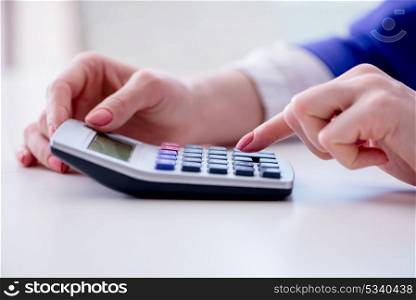 Hands working on accounting calculator calculating profit