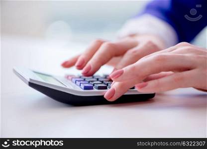Hands working on accounting calculator calculating profit