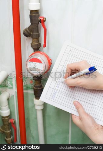 hands write down the water meter registration