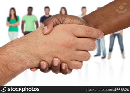Handshake between races a over white background with unfocused people of background