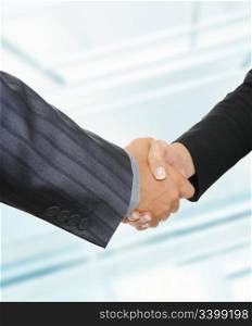 Handshake of business partners on the background of an office building