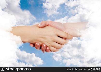 Handshake of two business people against the sky. Symbol of successful business