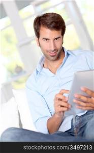 Handsom guy using electronic tablet at home