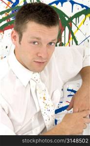 Handsome 26 year old business man against paint splashed background. Wearing white shirt and matching paint splashed tie. Head shot.