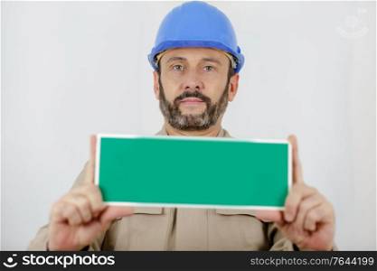 handsome adult male contractor holding sign