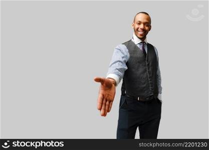 handsome african-american businessman handshake gesture over light grey background.. handsome african-american businessman handshake gesture over light grey background