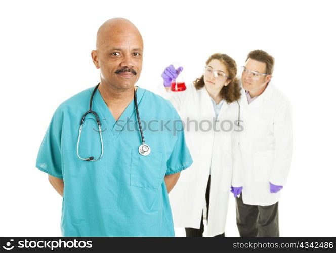 Handsome African-american surgeon with lab techs in background. Isolated on white.