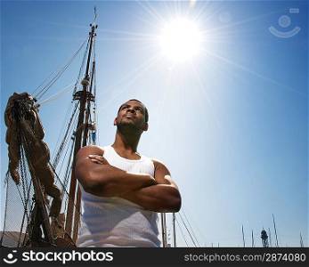 Handsome afro-american man against boat&acute;s mast.