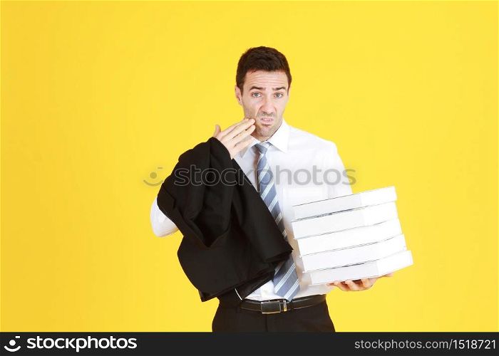 Handsome and smart businessman in suit and white shirthand holding document books isolated on yellow background. Copy Space