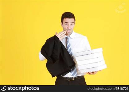 Handsome and smart businessman in suit and white shirthand holding document books isolated on yellow background. Copy Space