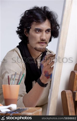 Handsome artist focusing on painting
