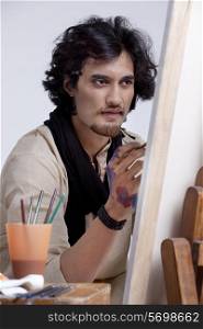 Handsome artist focusing on painting