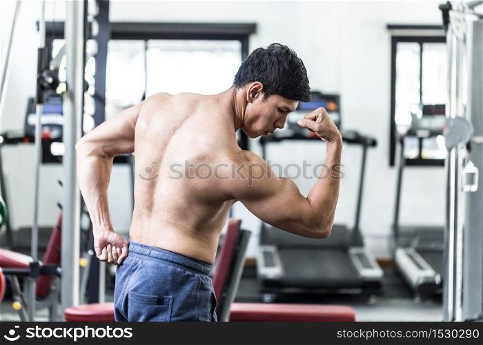 Handsome Attractive Asian men doing bodybuilder Side Biceps pose in gym feeling so strong and powerful after workout,Bodybuilder Concept