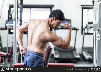 Handsome Attractive Asian men doing bodybuilder Side Biceps pose in gym feeling so strong and powerful after workout,Bodybuilder Concept