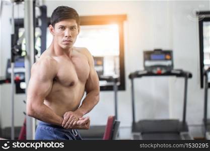 Handsome Attractive Asian men doing bodybuilder Side Chest pose in gym feeling so strong and powerful,Bodybuilder Concept