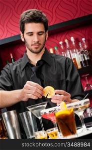 Handsome barman professional at posh bar making cocktail drinks