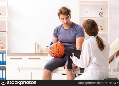 Handsome basketball player visiting female doctor traumatologist   . Handsome basketball player visiting female doctor traumatologist