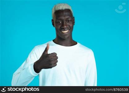 Handsome black man shows thumbs up, Like gesture. Happy guy on blue background. Winner. Success. Positive male african model smiles to camera. Body language. Handsome black man shows thumbs up, Like gesture. Happy guy on blue background. Winner. Success. Positive male african model smiles to camera. Body language.