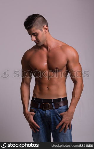 Handsome bodybuilder with a great body posing over a copy space background