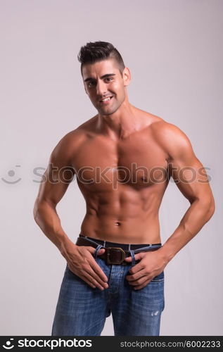 Handsome bodybuilder with a great body posing over a copy space background