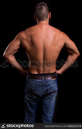 Handsome bodybuilder with a great body posing over a copy space background