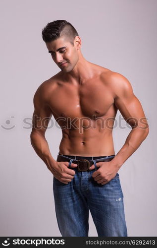 Handsome bodybuilder with a great body posing over a copy space background