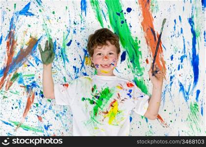 Handsome boy playing with painting with the background painted