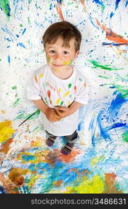 Handsome boy playing with painting with the background painted