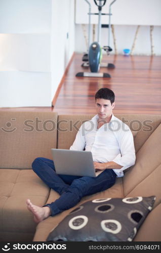 handsome business man in casual clothing working on laptop computer from home and drink firs morning coffee