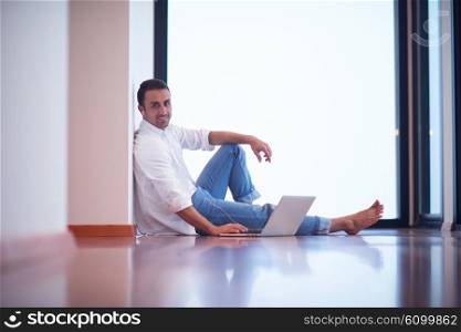 handsome business man in casual clothing working on laptop computer from home and drink firs morning coffee