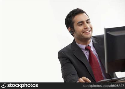 Handsome business man using computer while on call
