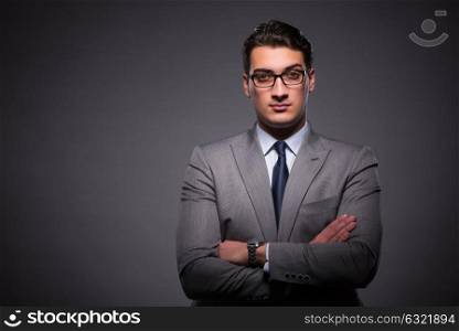 Handsome businessman against dark background
