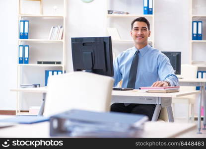 Handsome businessman employee sitting at his desk in office