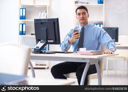 Handsome businessman employee sitting at his desk in office