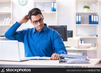 Handsome businessman employee sitting at his desk in office