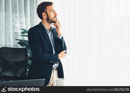 Handsome businessman in black suit stand confidently in his modern office portrait, deep in thought about business with pensive gazing expression, thinking strategically about his next move. Entity. Businessman in black suit stand confidently in modern office portrait. Entity