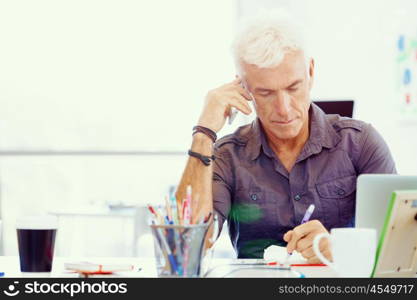 Handsome businessman in office. Handsome businessman in casual wear working in office